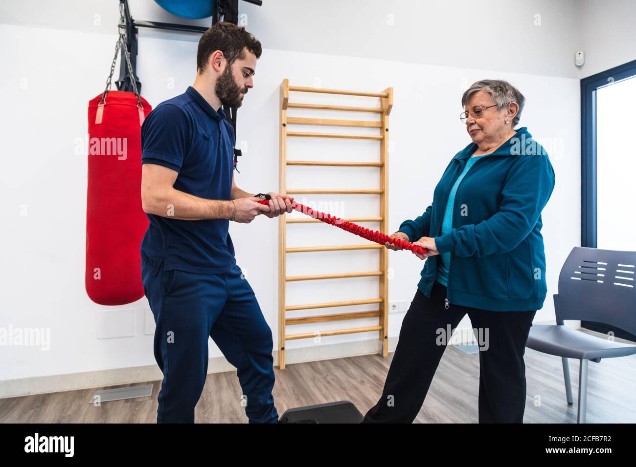 Fitness trainer and senior Woman doing physiotherapy exercises with