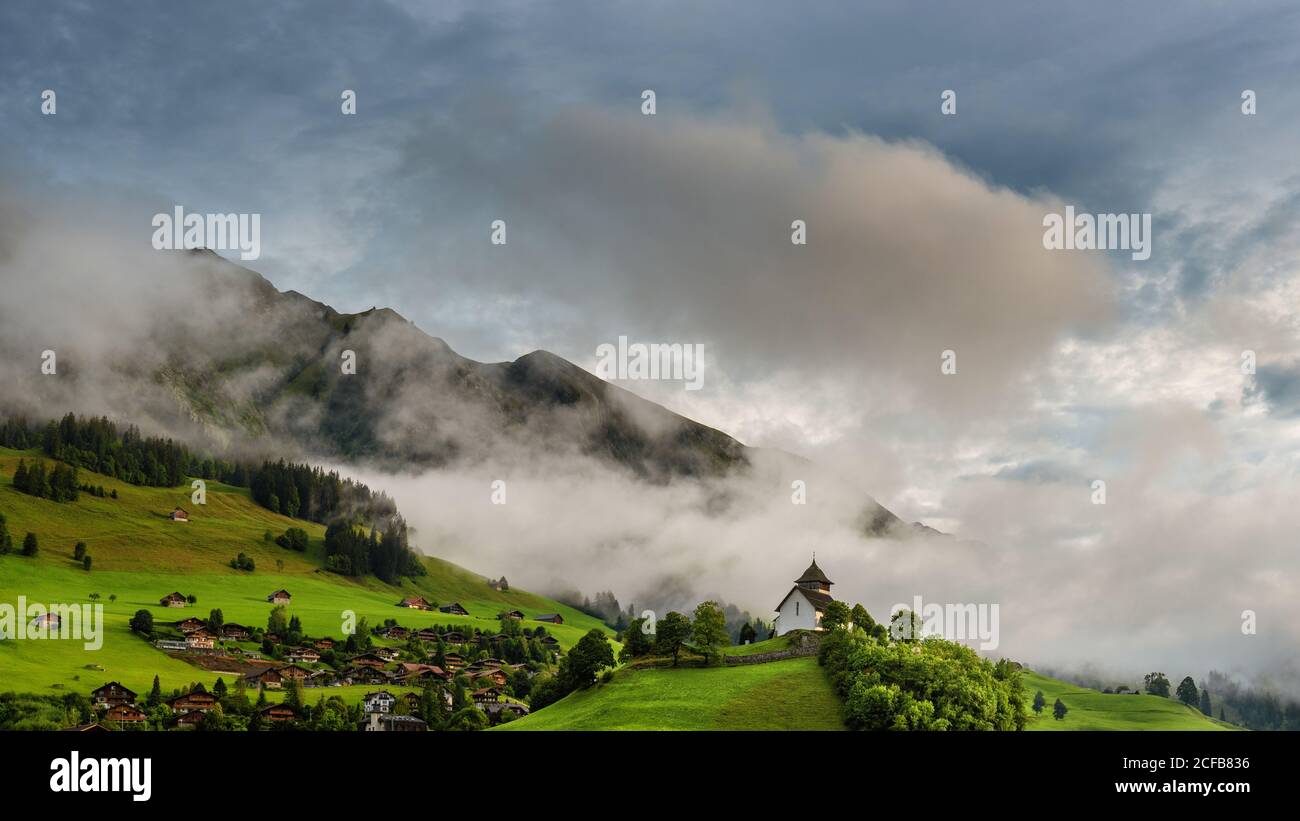 Le Temple - Chateau d'Oex church on the hill. Panoramic landscape of Switzerland Stock Photo
