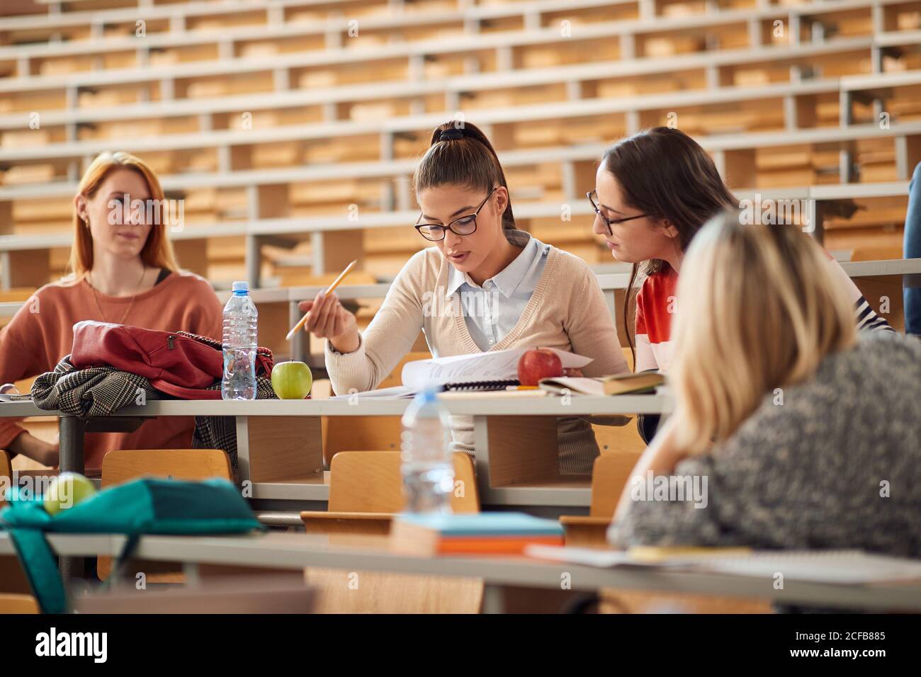 Female students learning together in amphitheater Stock Photo