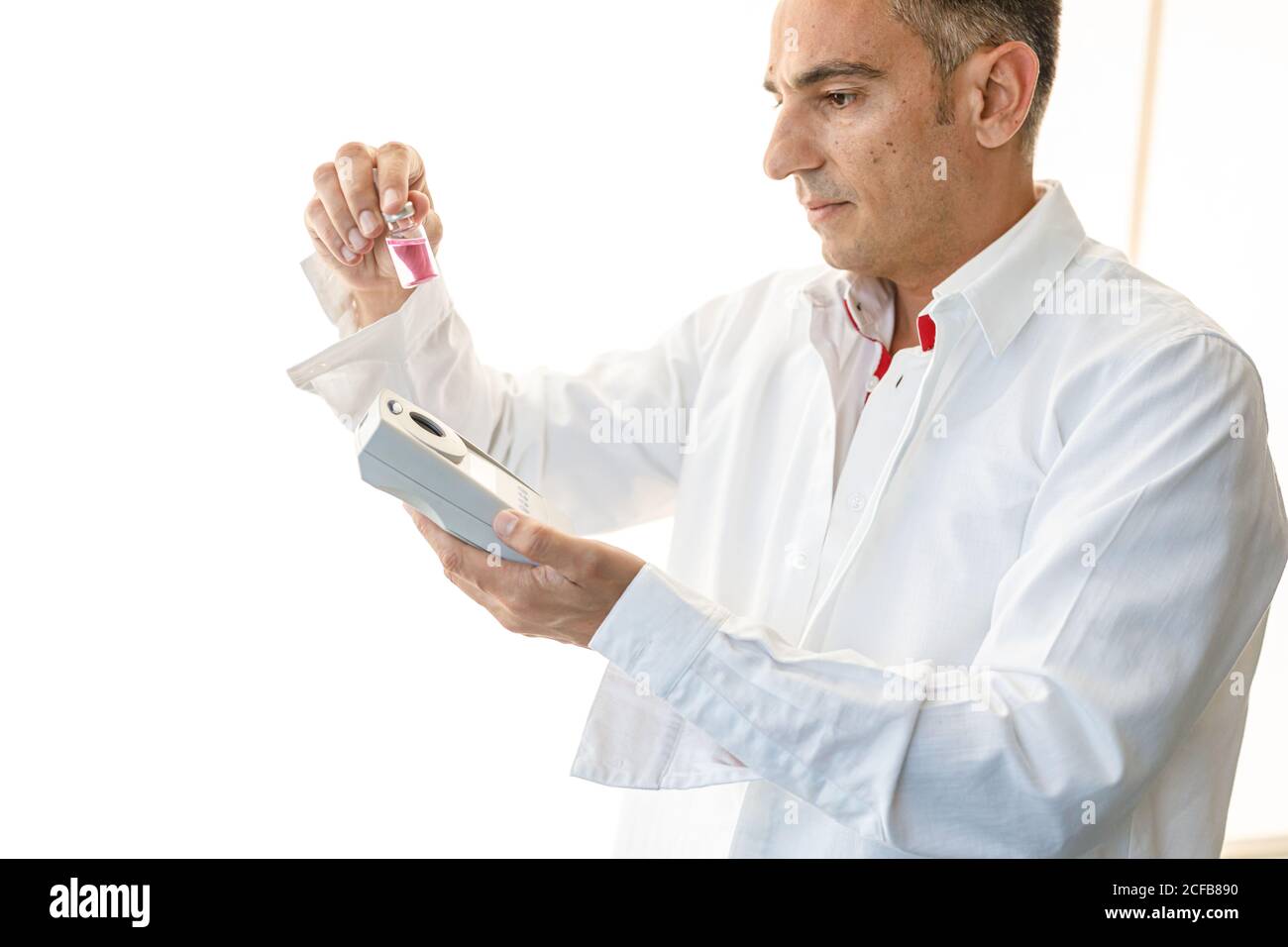 Assistant working in lab with pink liquid Stock Photo