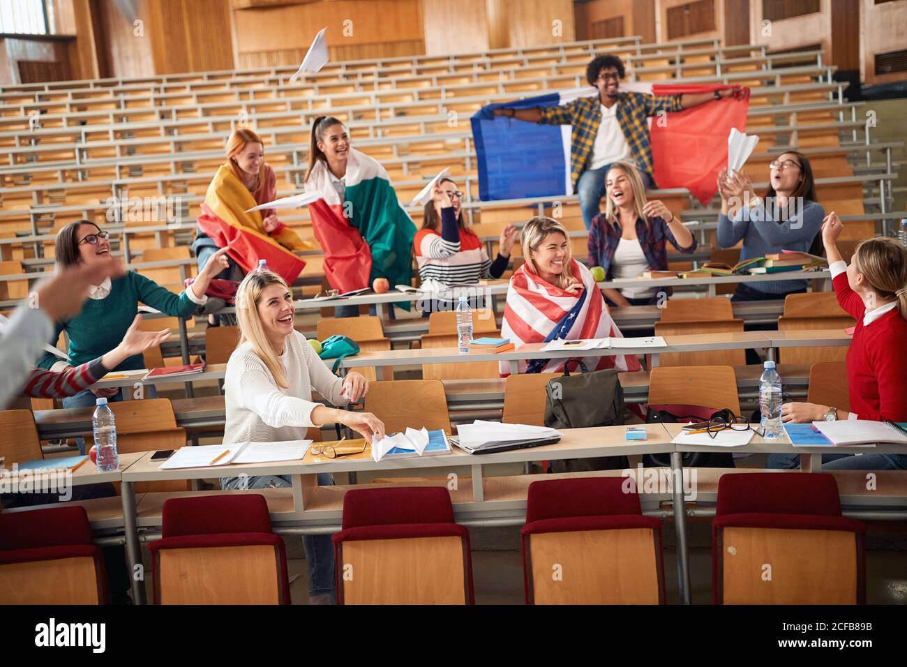 Happy students with flags in amphitheater together Stock Photo