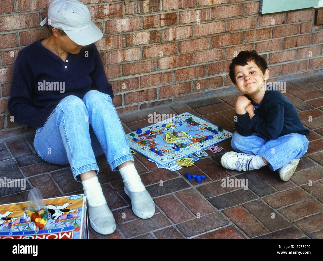 Boy playing Monopoly with mother Stock Photo