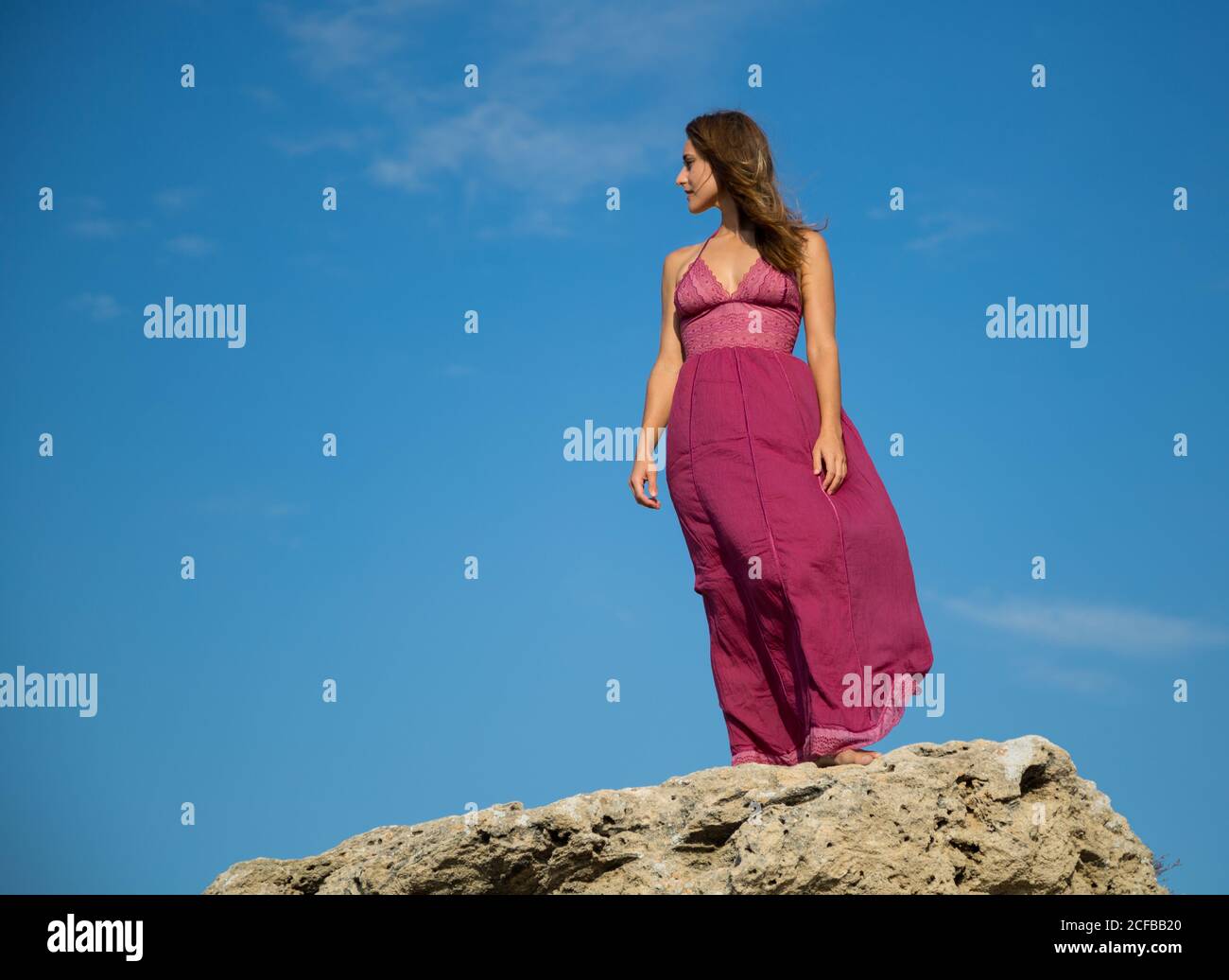 Woman in dress standing near stone monument Stock Photo - Alamy