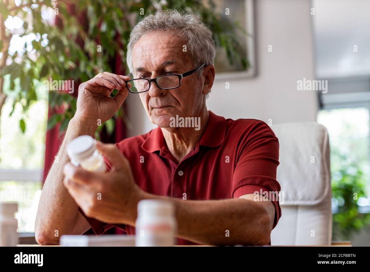 Senior man taking prescription medicine at home Stock Photo