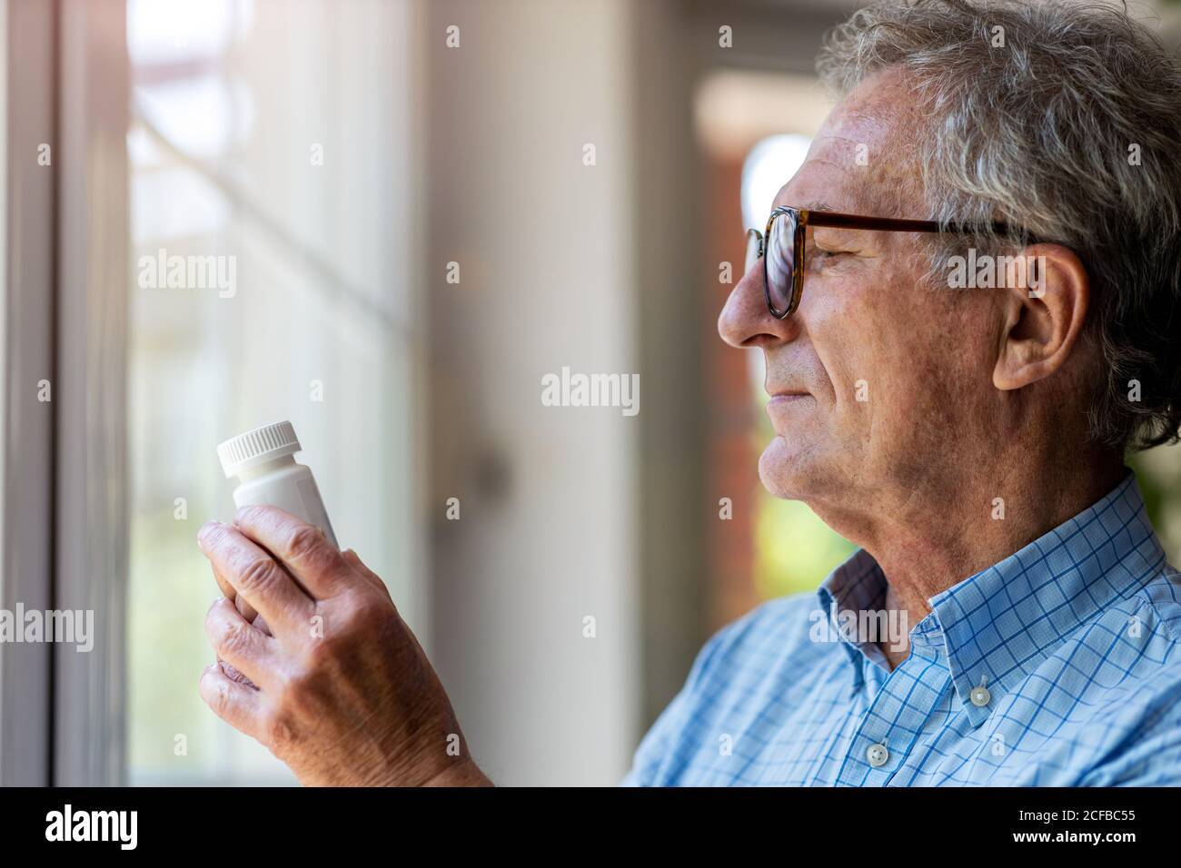 Senior man taking prescription medicine at home Stock Photo