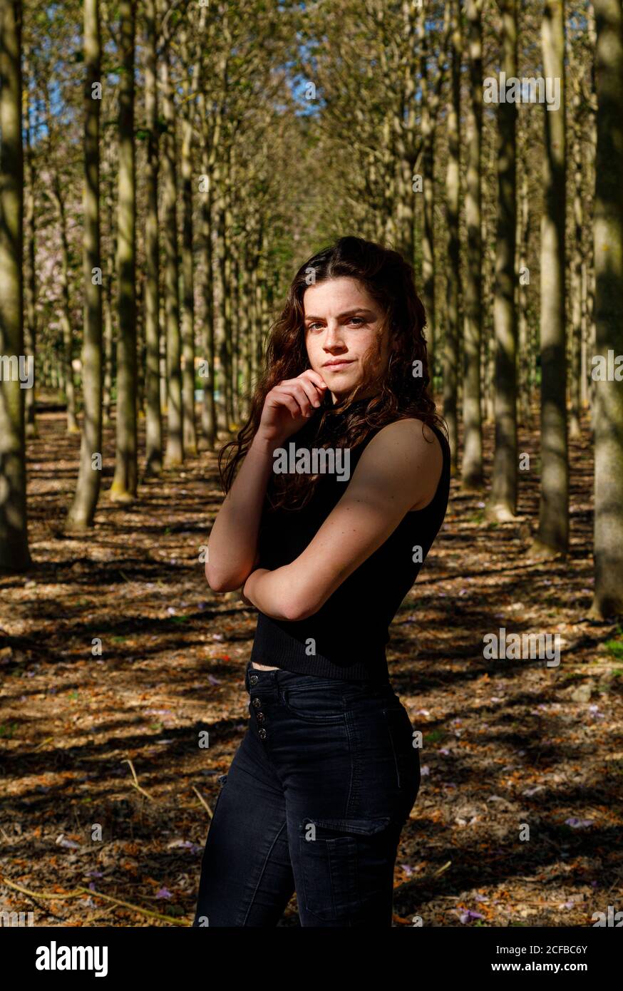 Beautiful young female standing in beautiful wood forest full of tall ...
