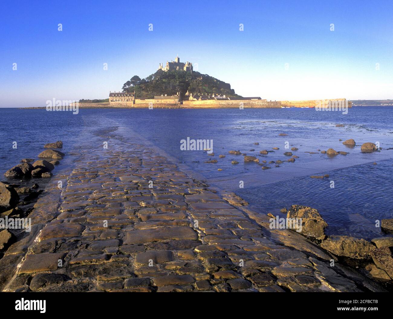 St Michaels Mount castle on a tidal island linked to mainland by man made causeway of granite setts visible at low tide Marazion Cornwall England UK Stock Photo
