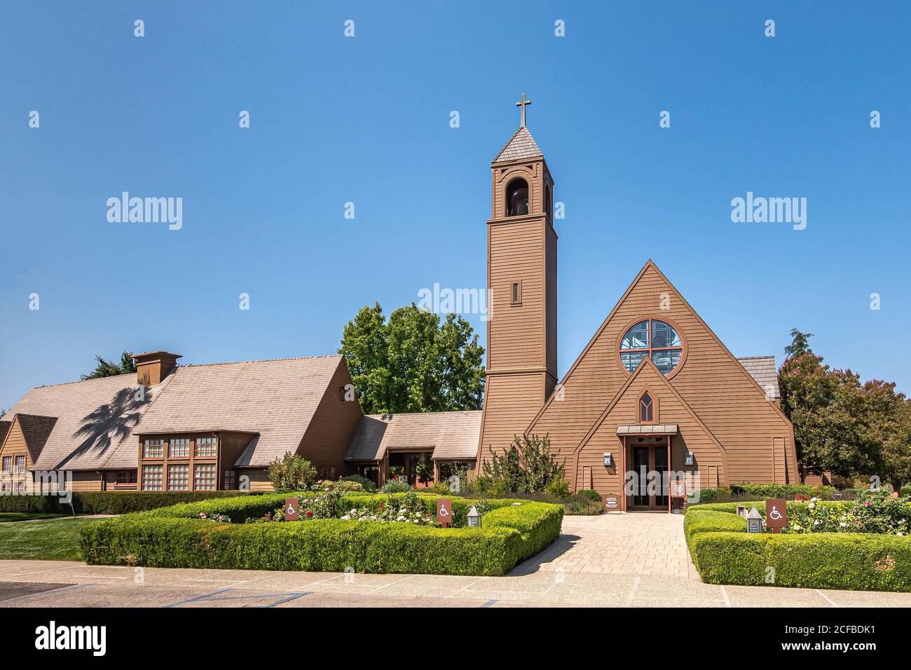 Los Olivos, California, USA - September 3, 2020: Frontal viw on brown wood St. Marks in the Valley Church with bell tower set in green park under blue Stock Photo