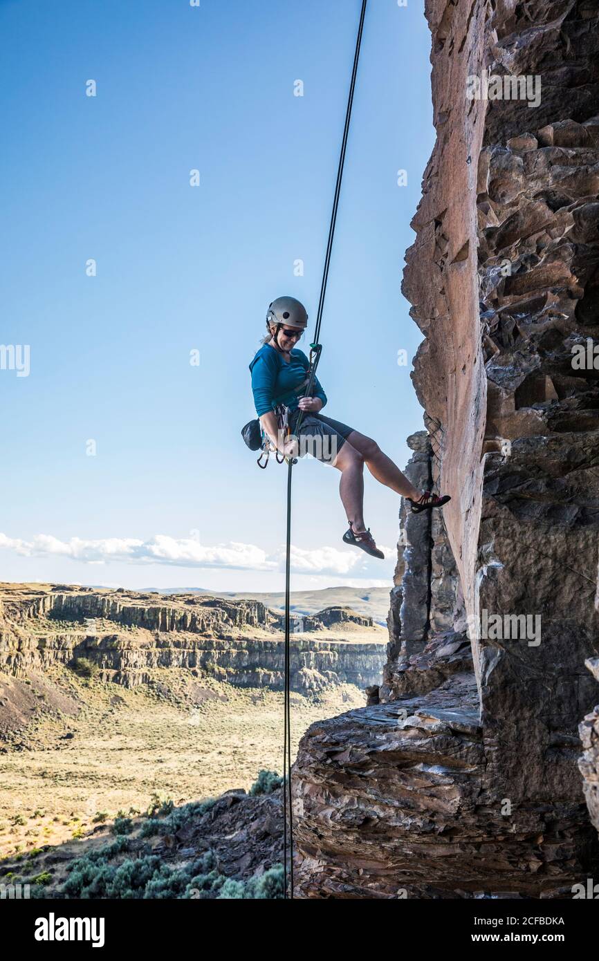A middle aged woman rappelling from a rock climb in Echo Basin near ...