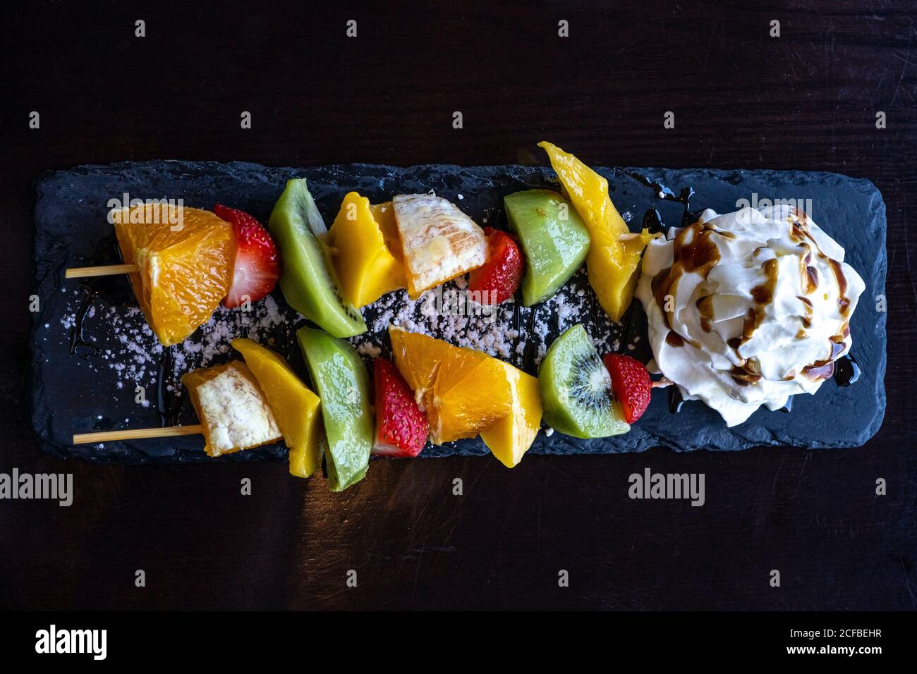 Fruit Kebab made of Oranges, Strawberries, Kiwi, Mango served with