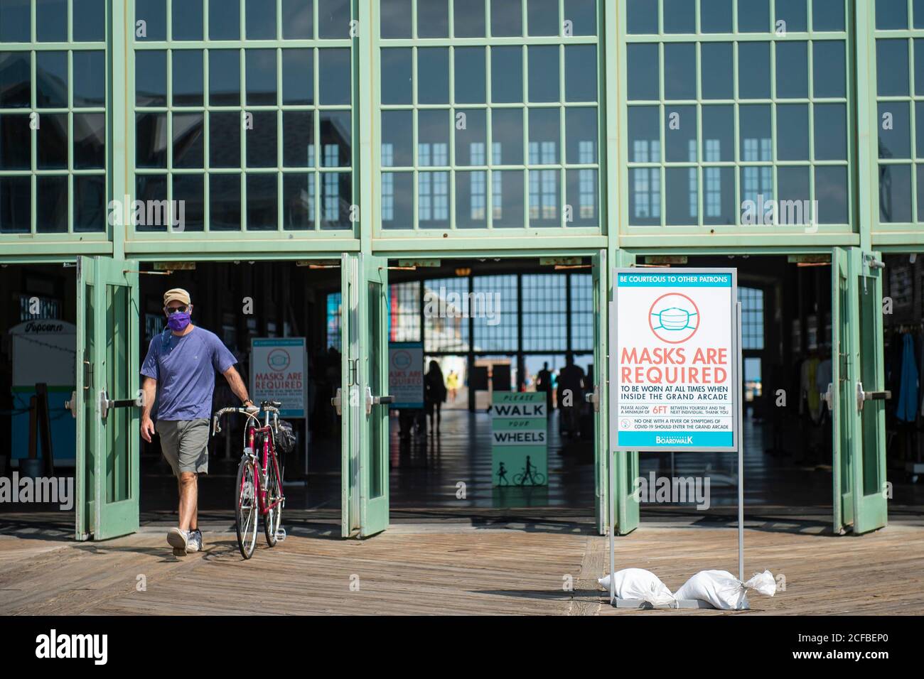 Asbury Park, New Jersey, USA. 04th Sep, 2020. A man walking a bike and