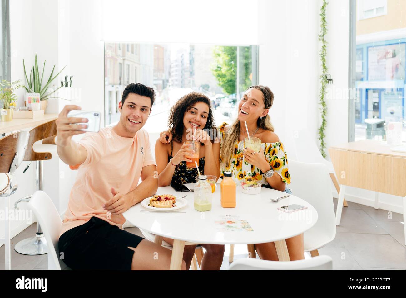 man taking selfie of friends in cafe Stock Photo