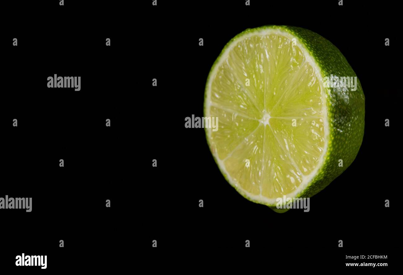 Sliced green lime on the black background. Stock Photo
