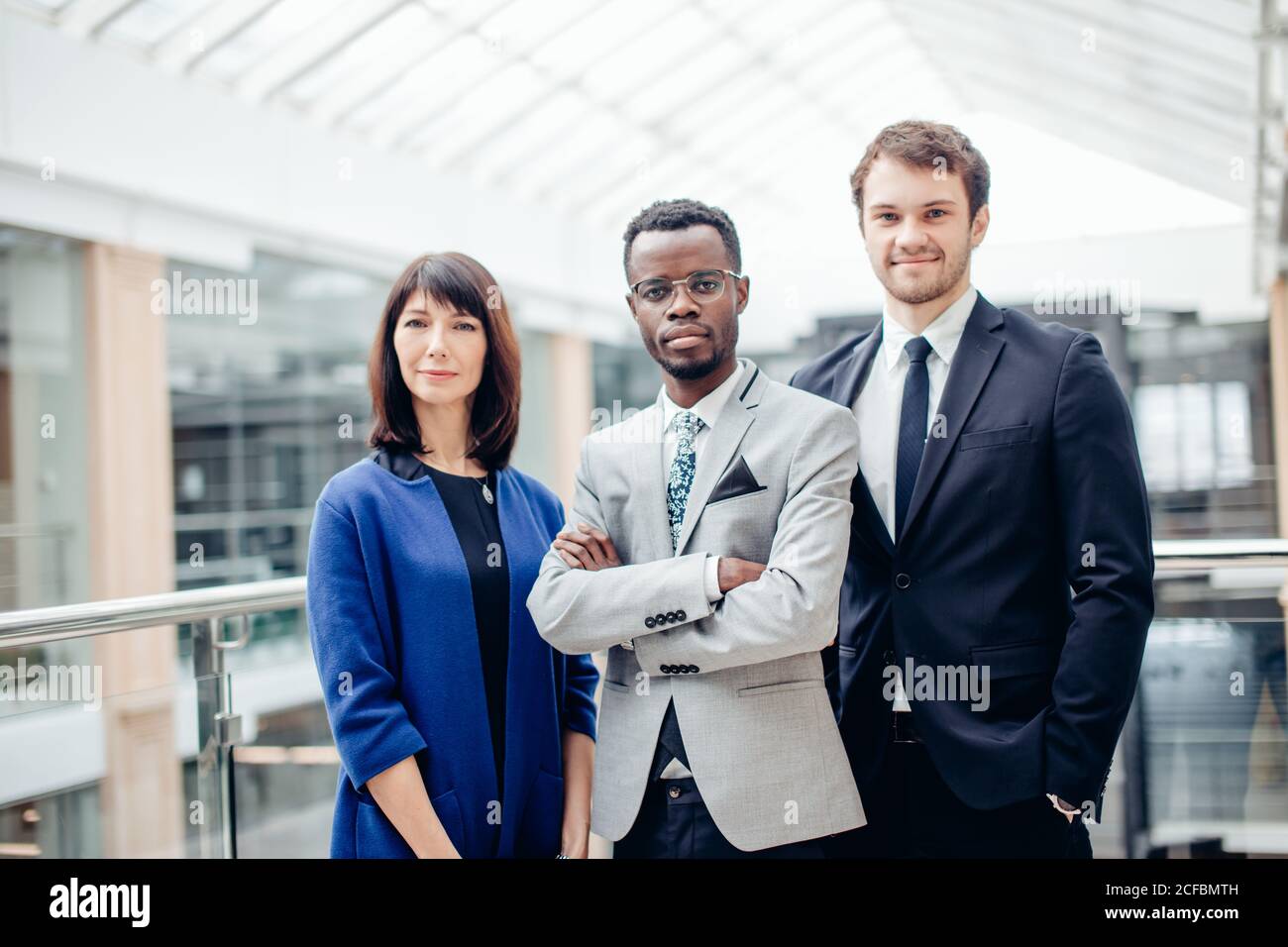 group of businesspeople standing together in office and looking at ...
