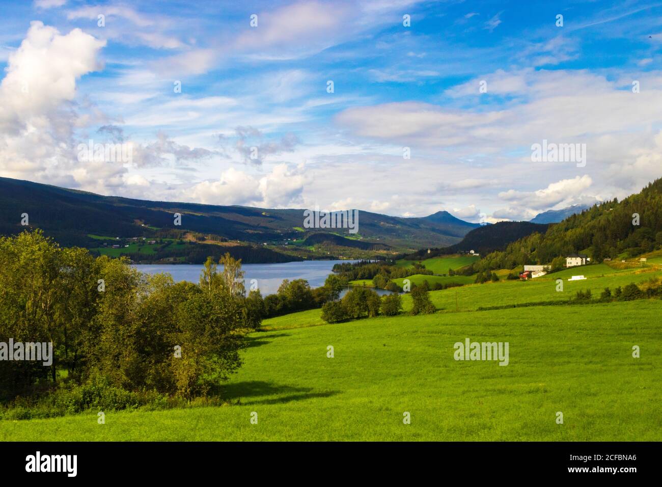 Farmhouse,summertime scenery,beautiful landscape,Slidrefjord lake shore,Kvåle village Innlandet county in Eastern Norway.seen from European route E16 Stock Photo
