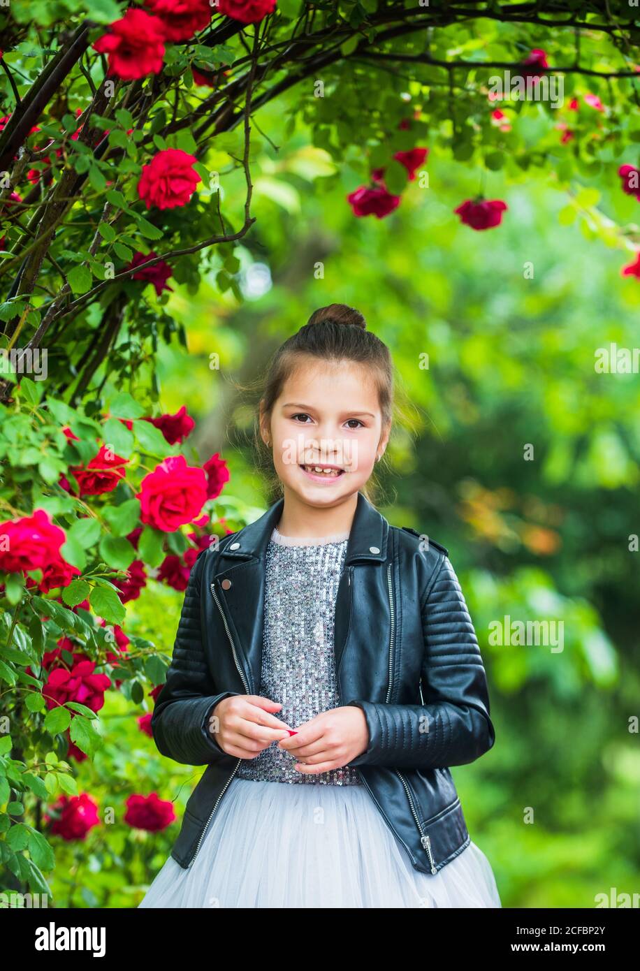 Trendy girl fancy dress and leather jacket in roses garden, stylish  combination concept Stock Photo - Alamy