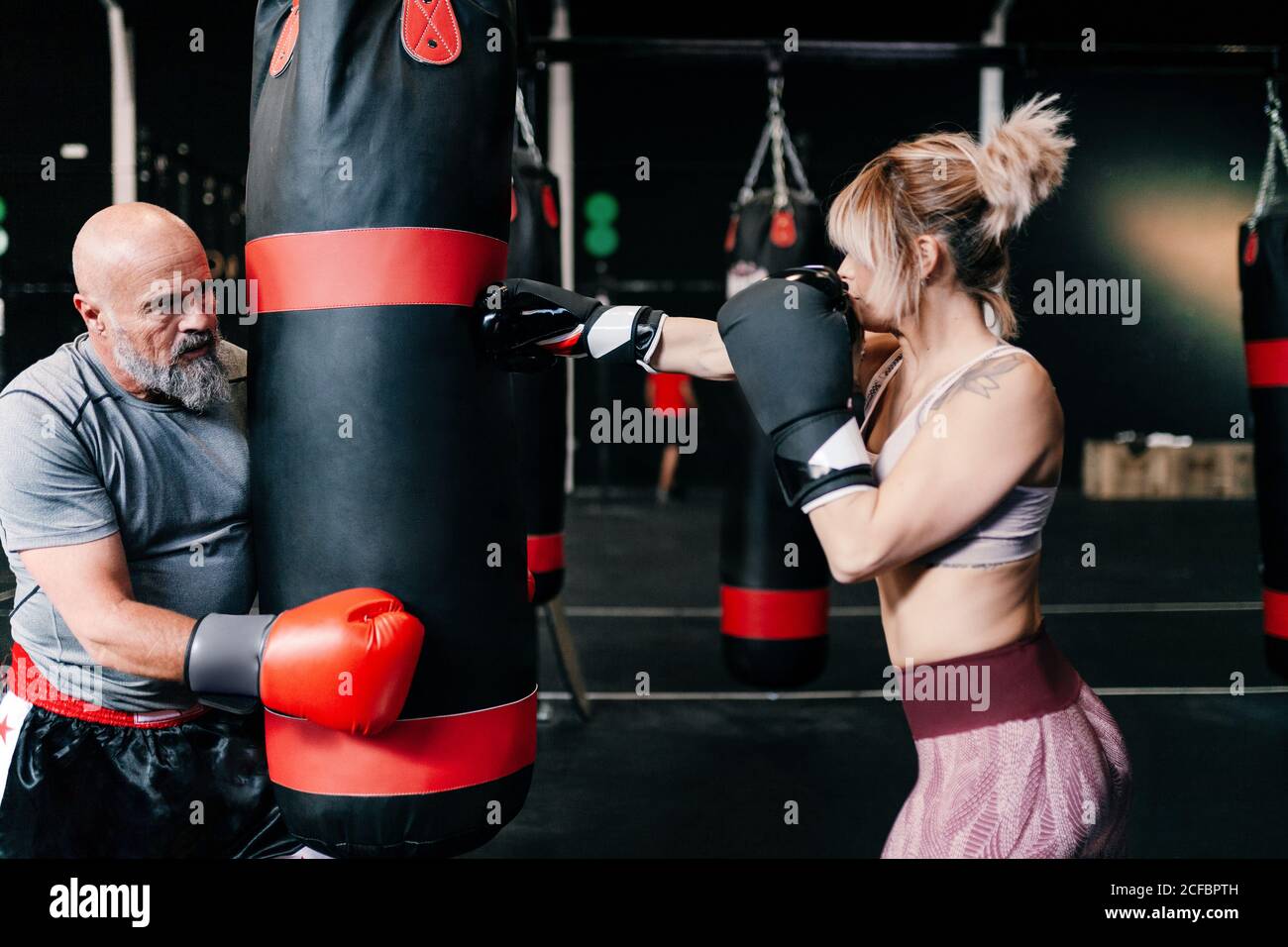 Side view of young boxer training hook on pad Stock Photo - Alamy