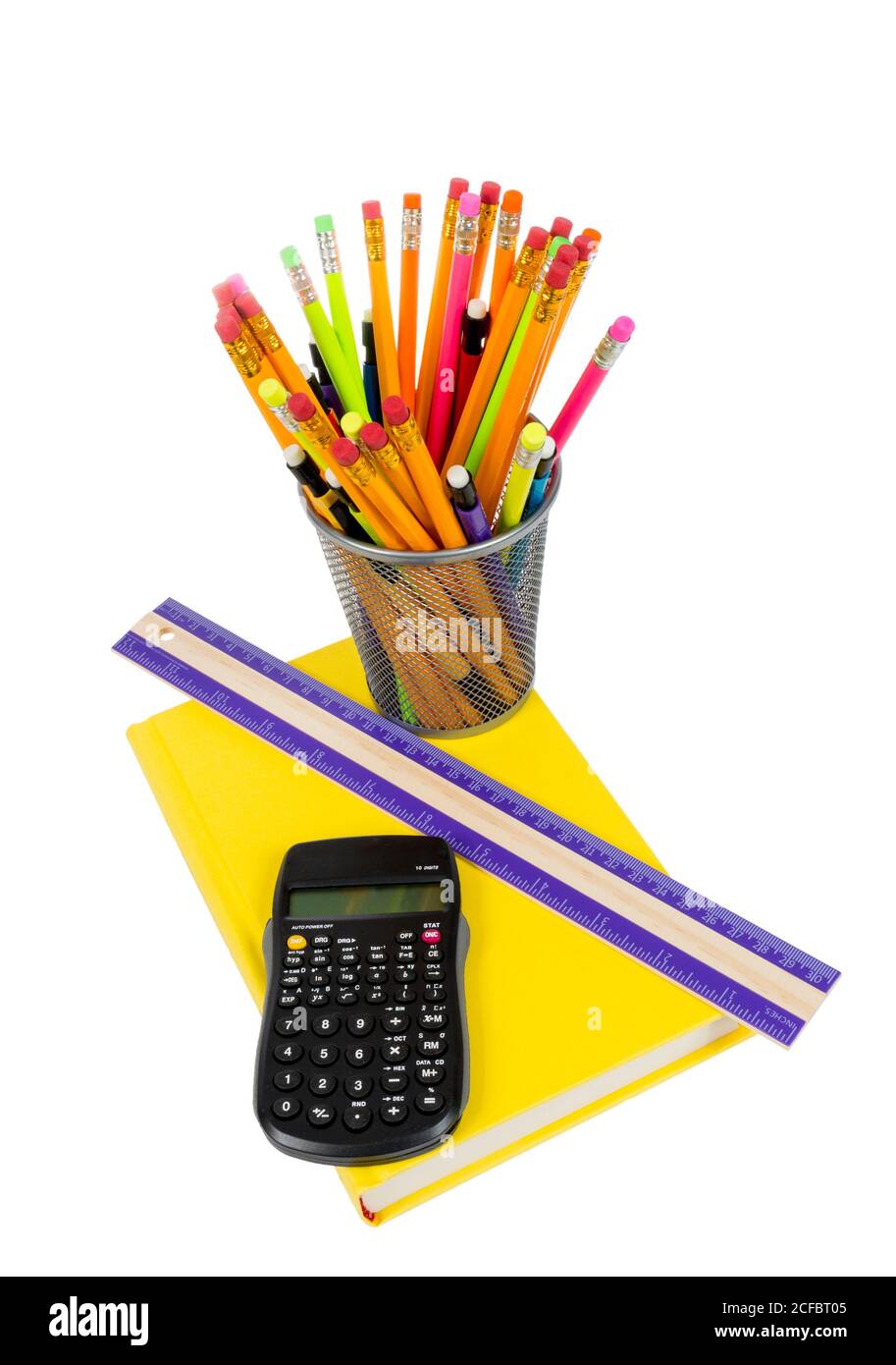 Vertical photograph of a rainbow color of pencils in pencil holder, with brightly colored yellow book, ruler and calculator. Isolated on a white backg Stock Photo