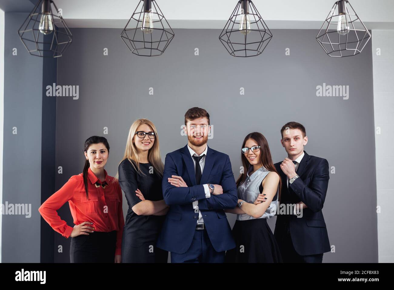 Happy business team with arms crossed at the office Stock Photo - Alamy