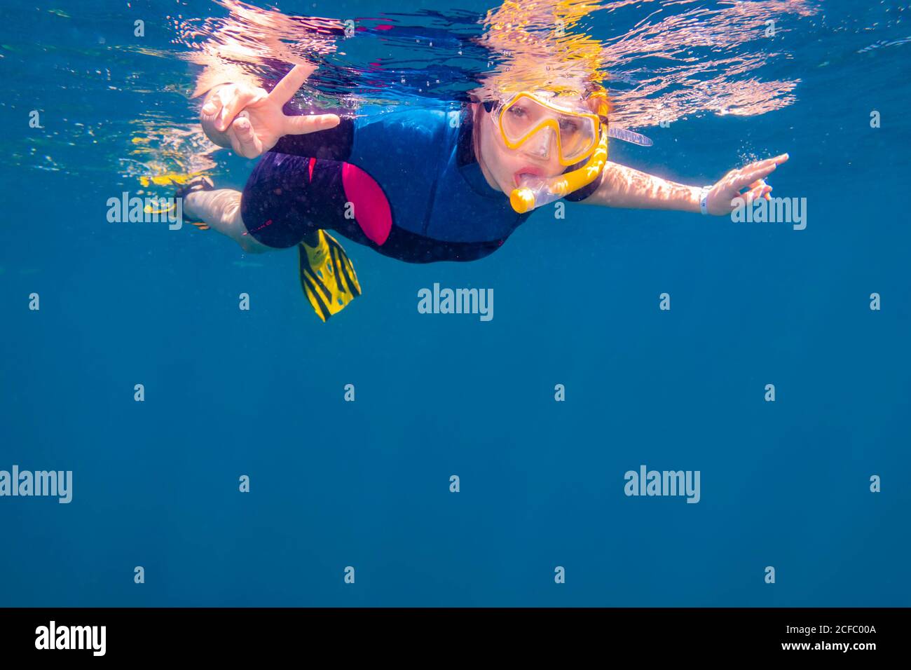 young woman snorkeling in the Ocean, Egypt, Marsa Alam, Africa, Girl with Wet Suit Snorkeling in Ocean Stock Photo