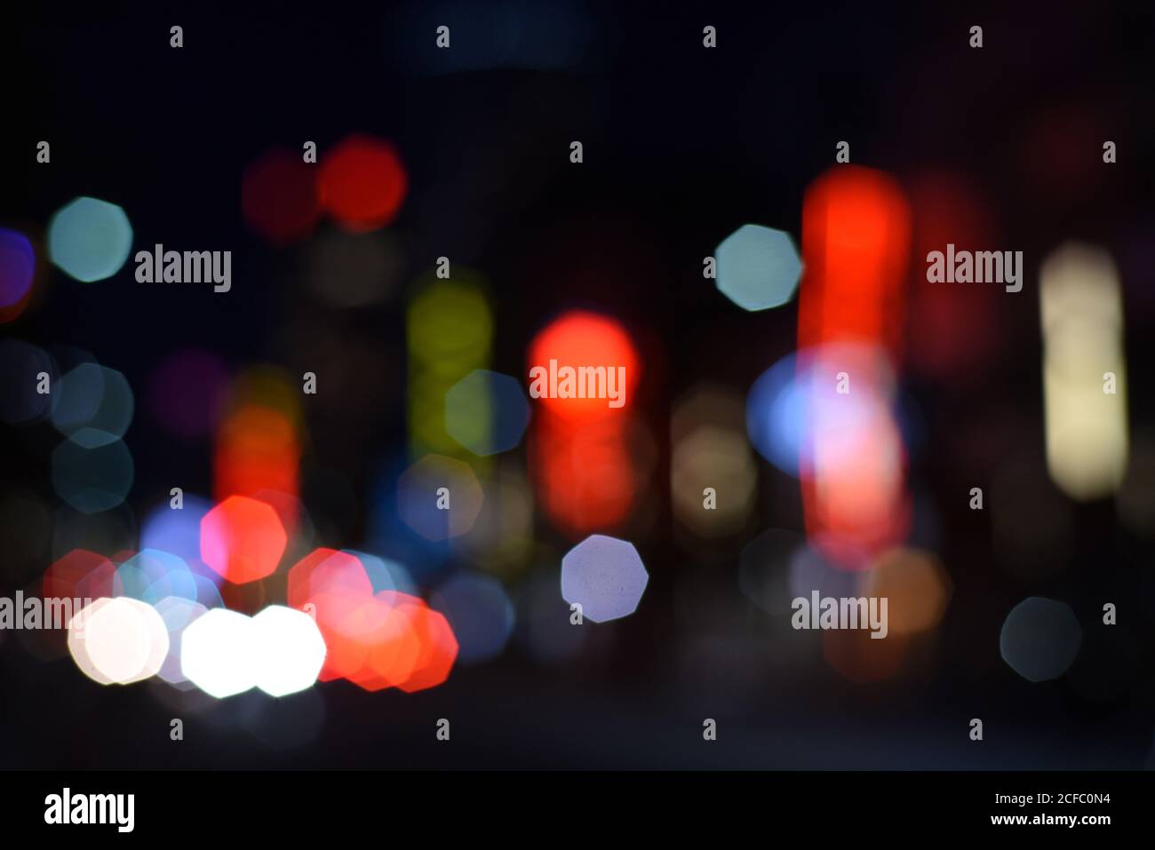 Out of focus building and vehicle lights form an impressionistic urban landscape Stock Photo