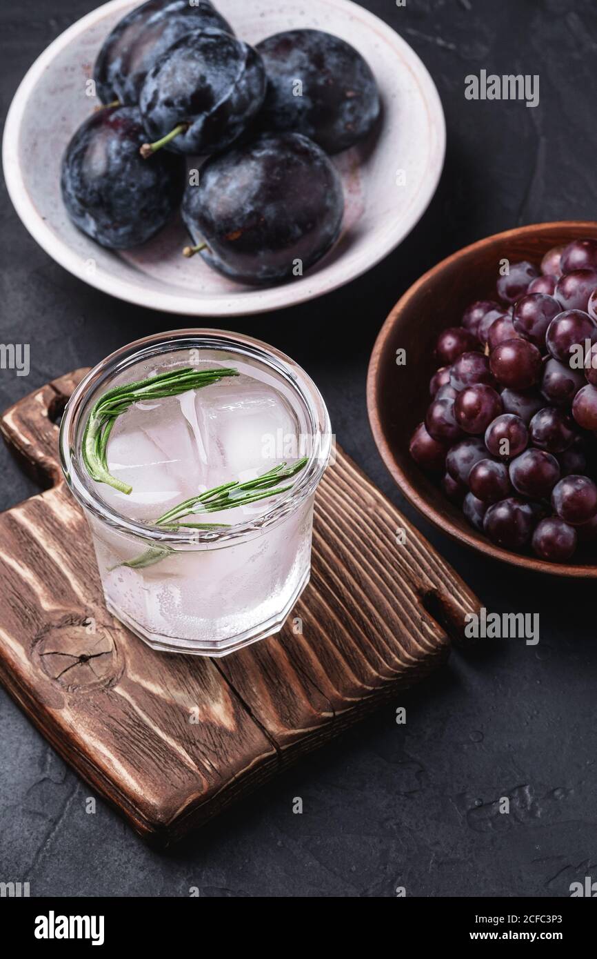 Fresh ice cold carbonated water in glass on cutting board with rosemary ...