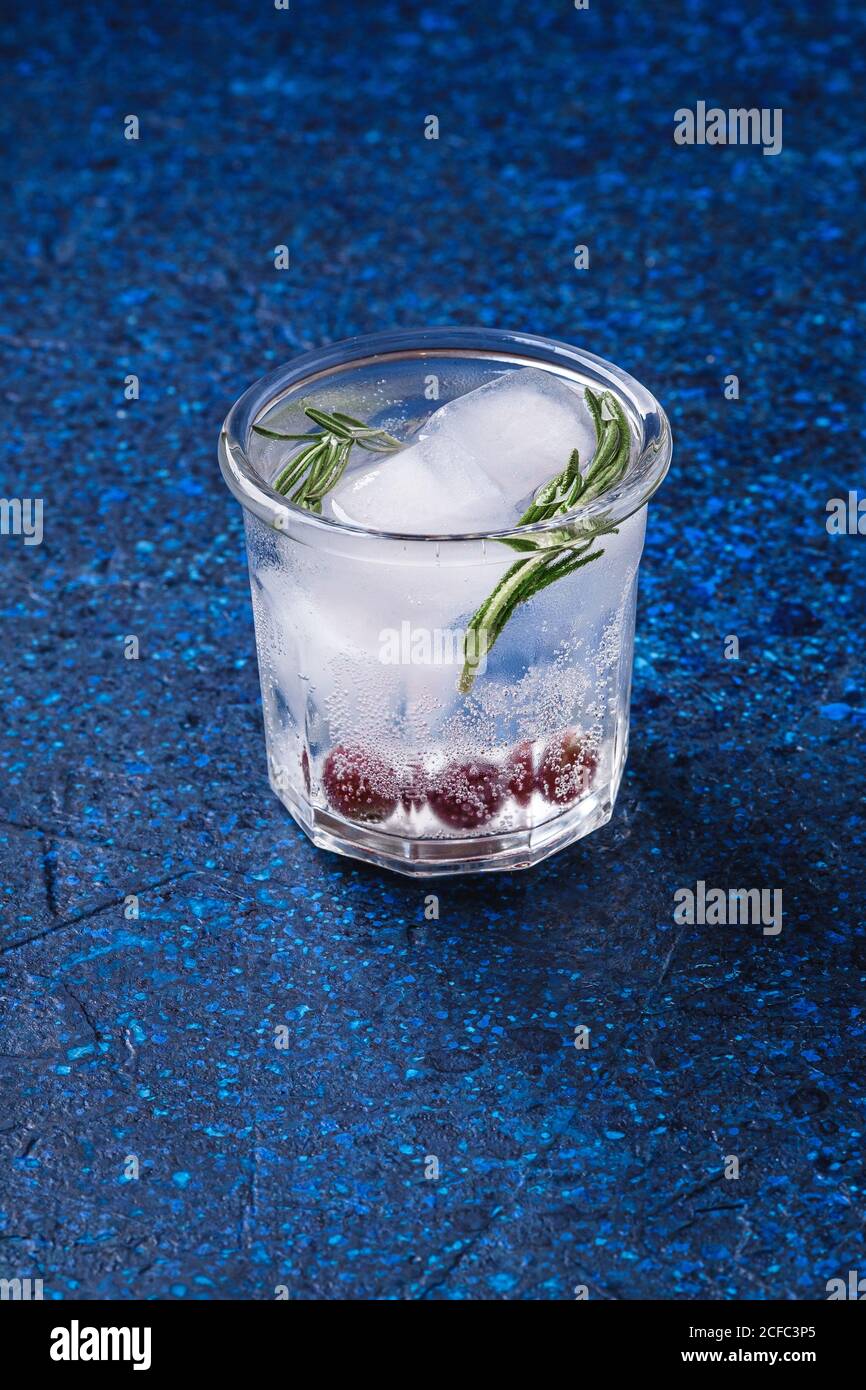 Fresh ice cold carbonated water drink in glass on blue textured ...