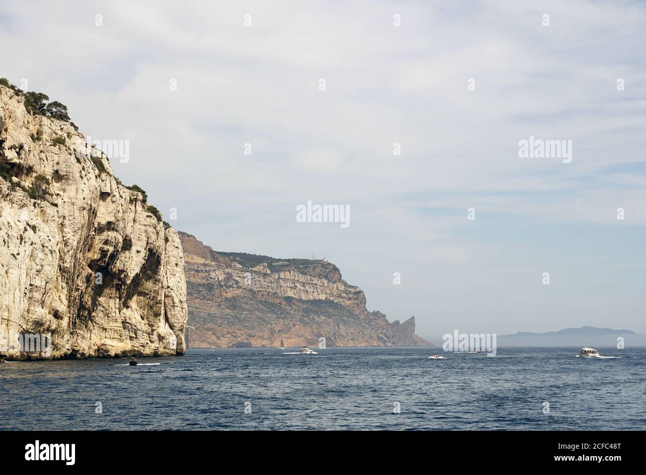 Limestone rocks and boats sailing in sea Stock Photo - Alamy