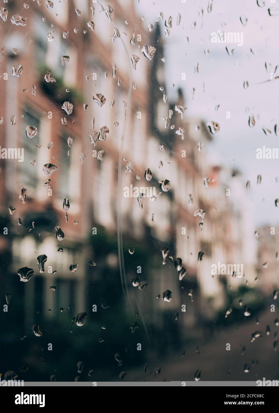 Blurry view of city street though glass covered with raindrops Stock ...