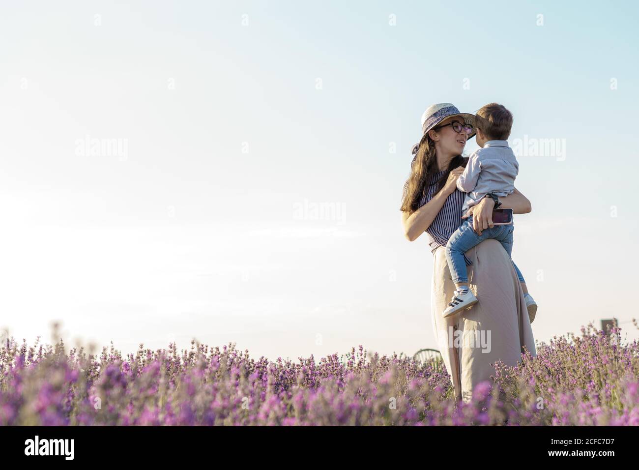 Large family, fatherhood, childhood, motherhood, provence style concept - happy young mom with little kid boy son of Middle Eastern appearance holds Stock Photo