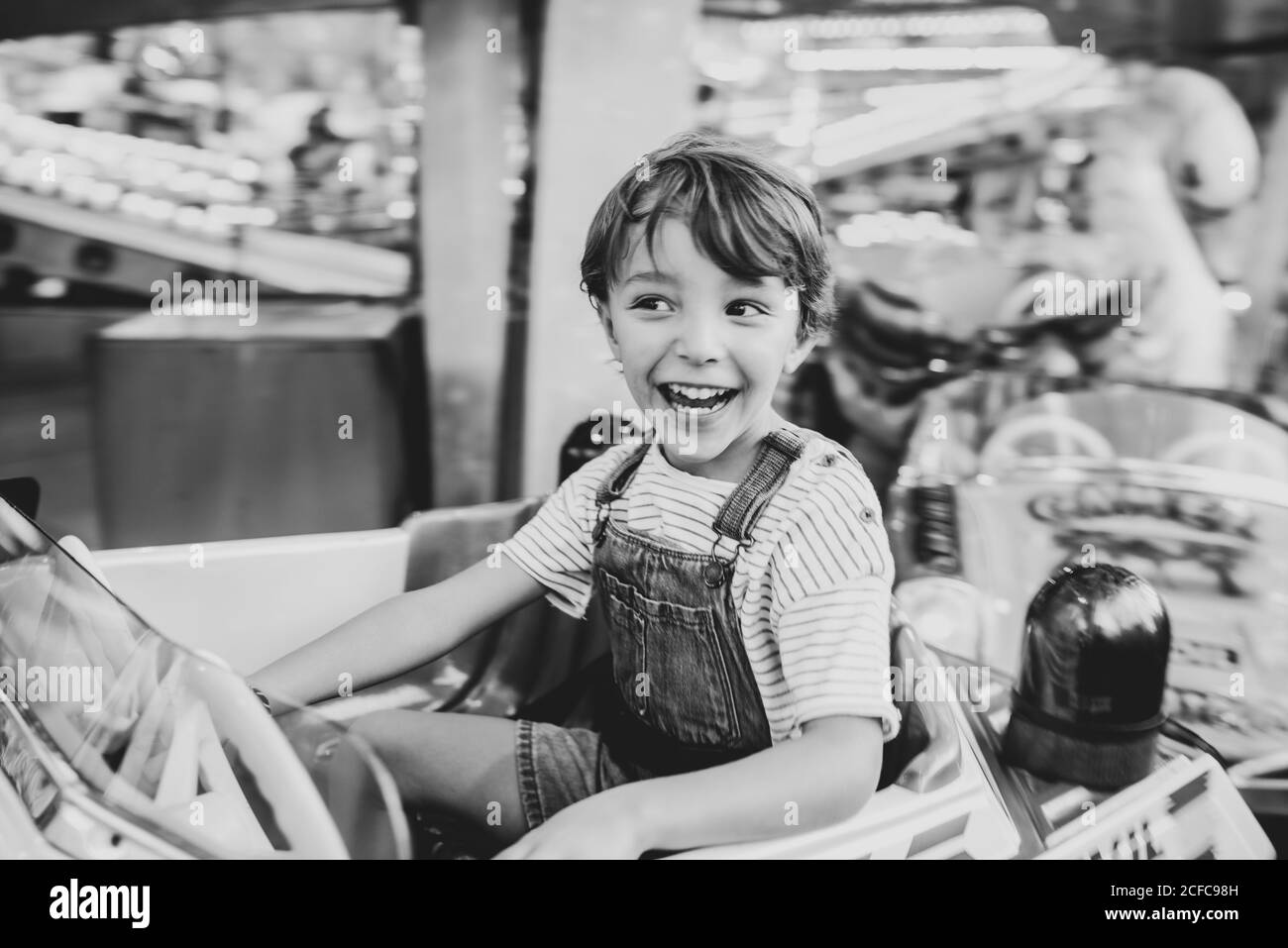 Happy boy riding carousel on fairground Stock Photo