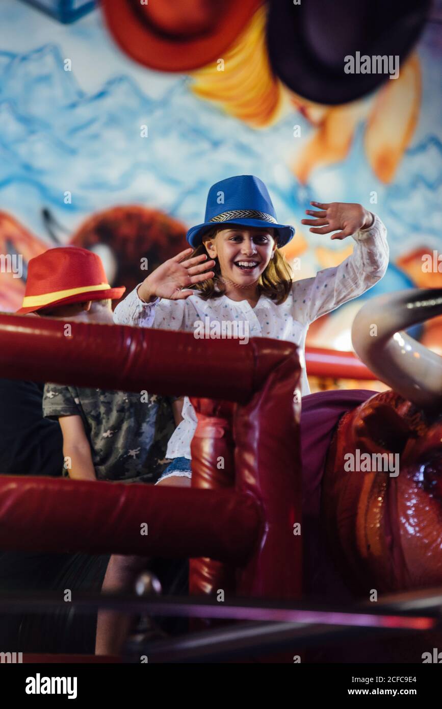 Cheerful girl riding mechanical bull Stock Photo