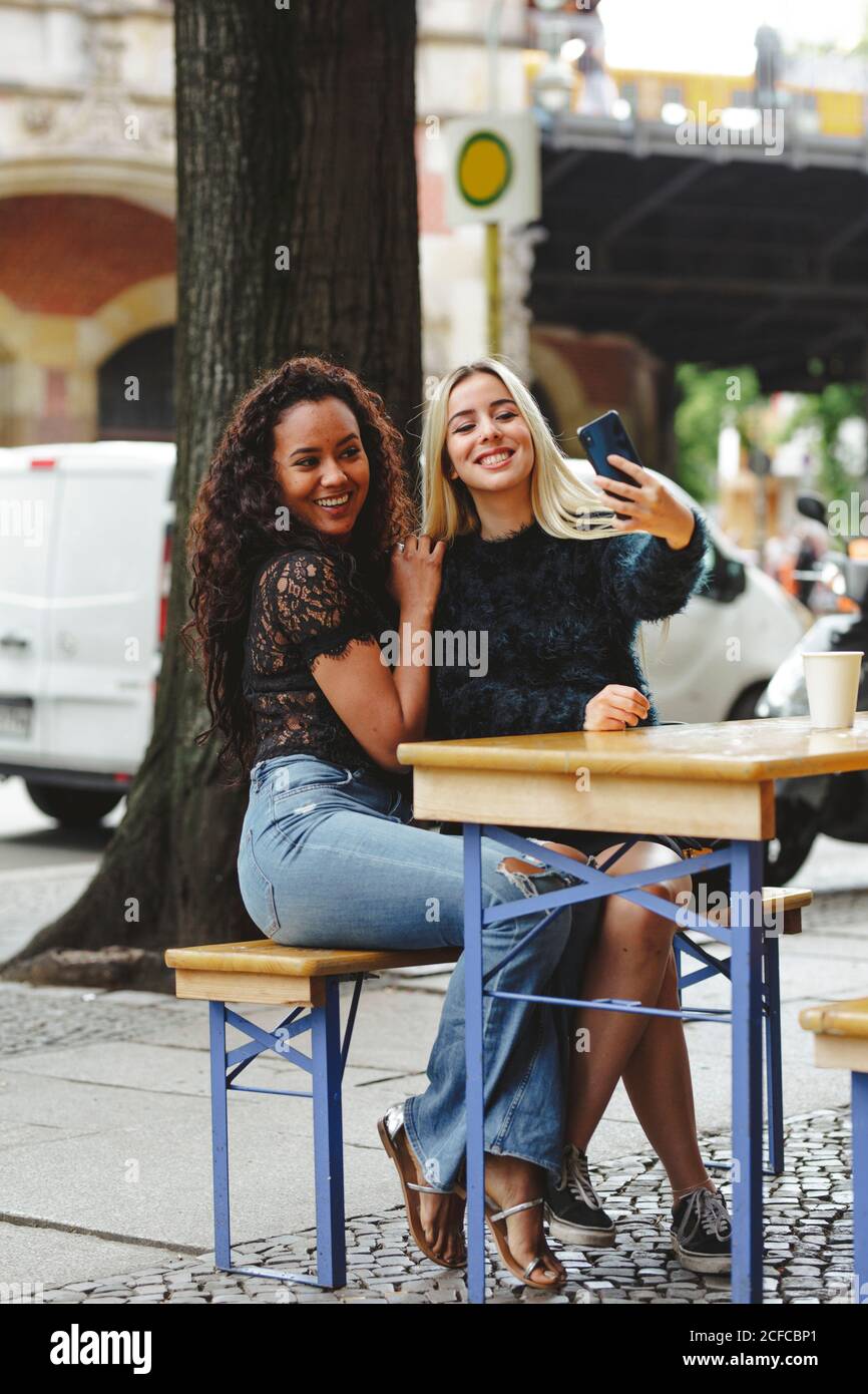 beautiful young women sitting in Berlin street cafe taking selfie Stock