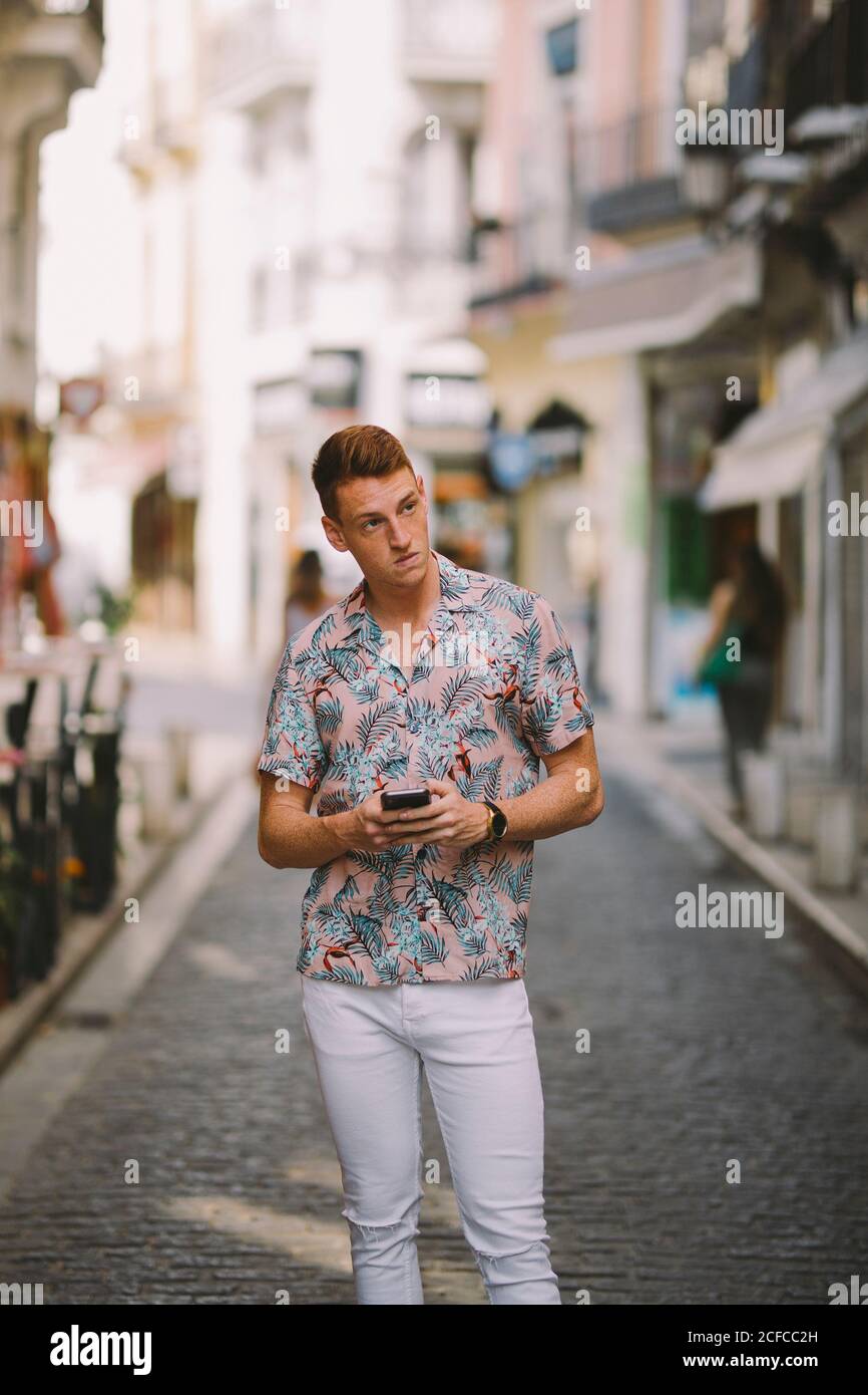 Adult guy in a Hawaiian shirt, walking down the street Stock Photo
