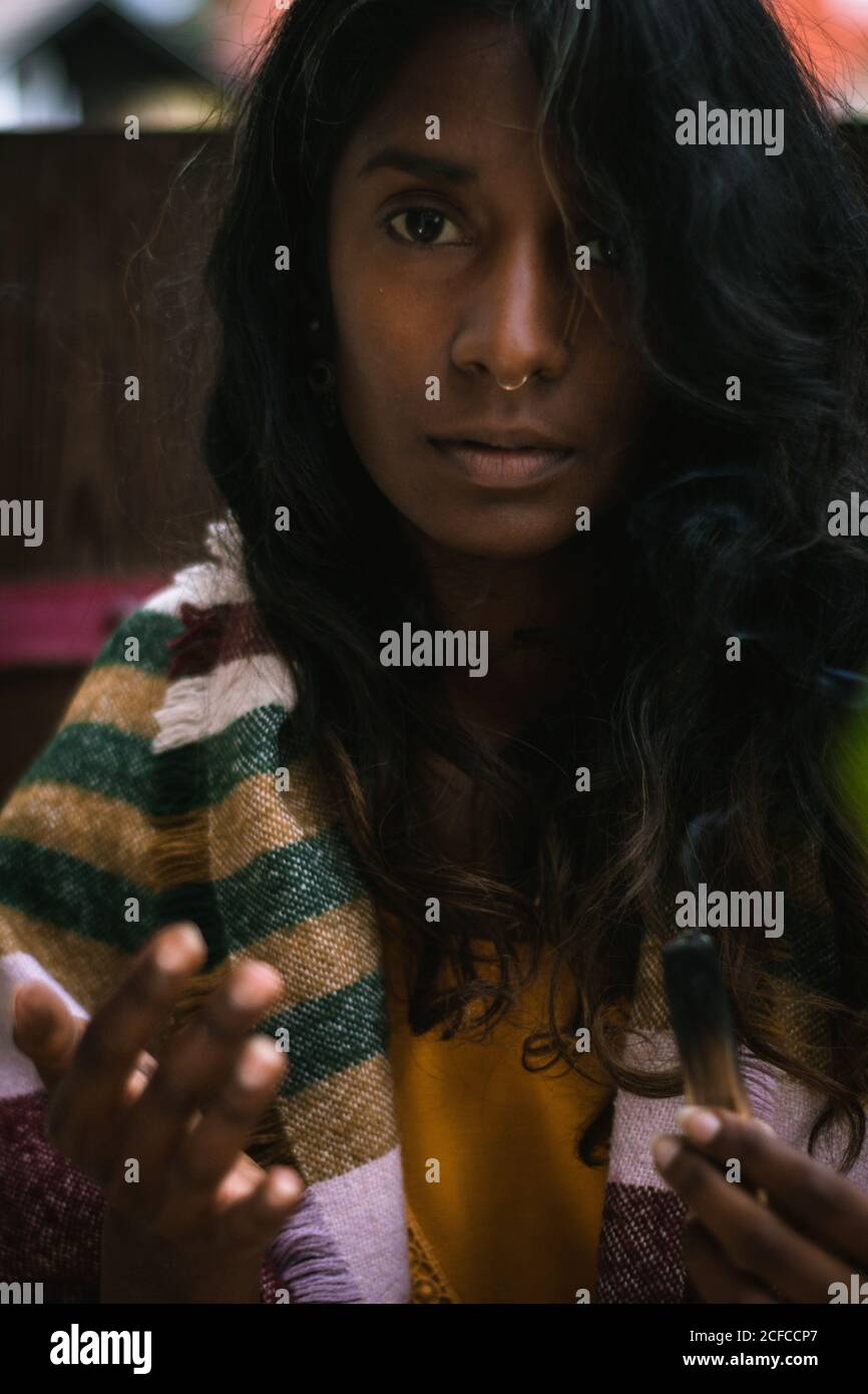 Spiritual young ethnic female looking at camera in traditional clothes