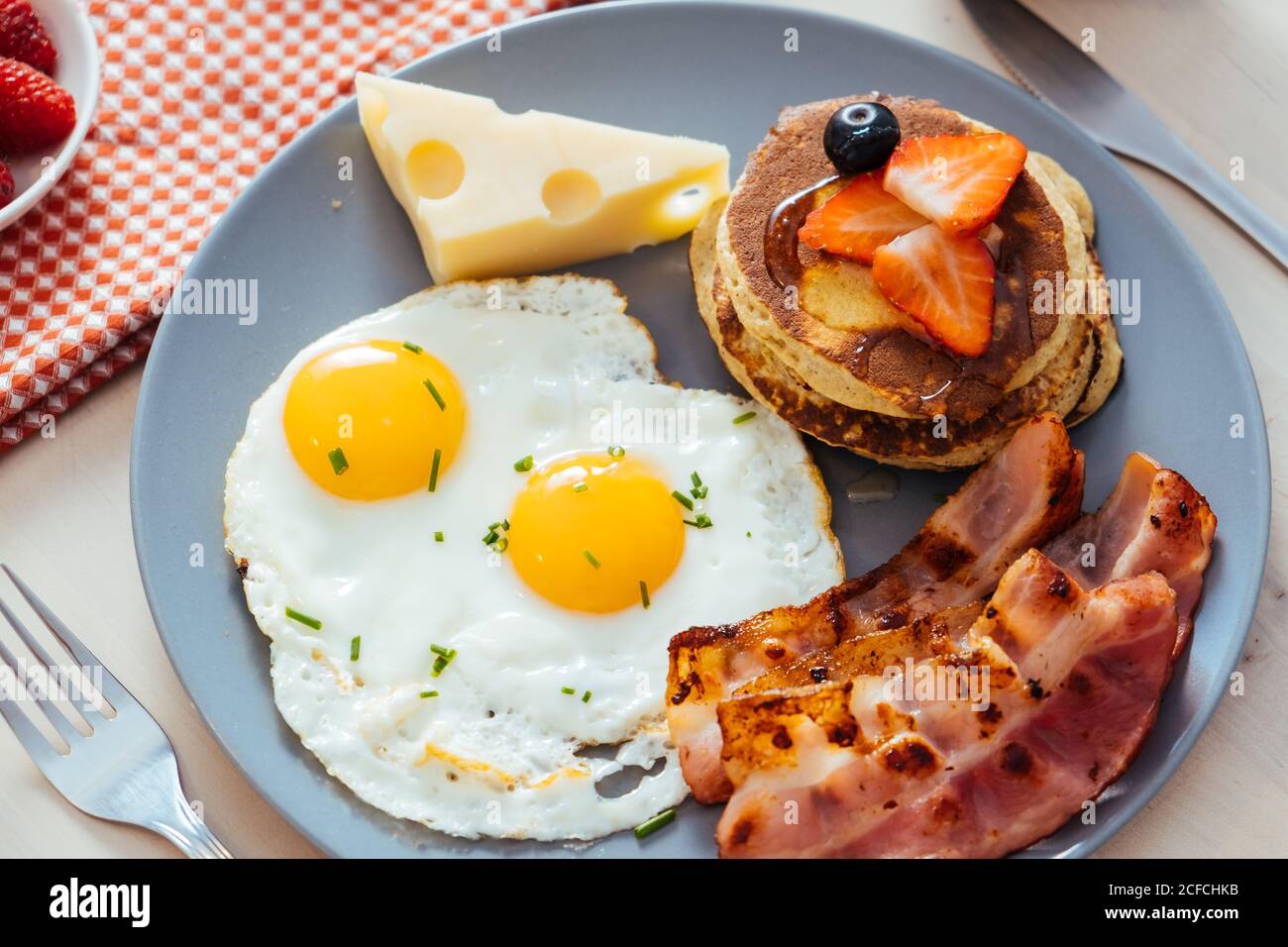 Delicious fried eggs with bacon and cheese for breakfast Stock Photo