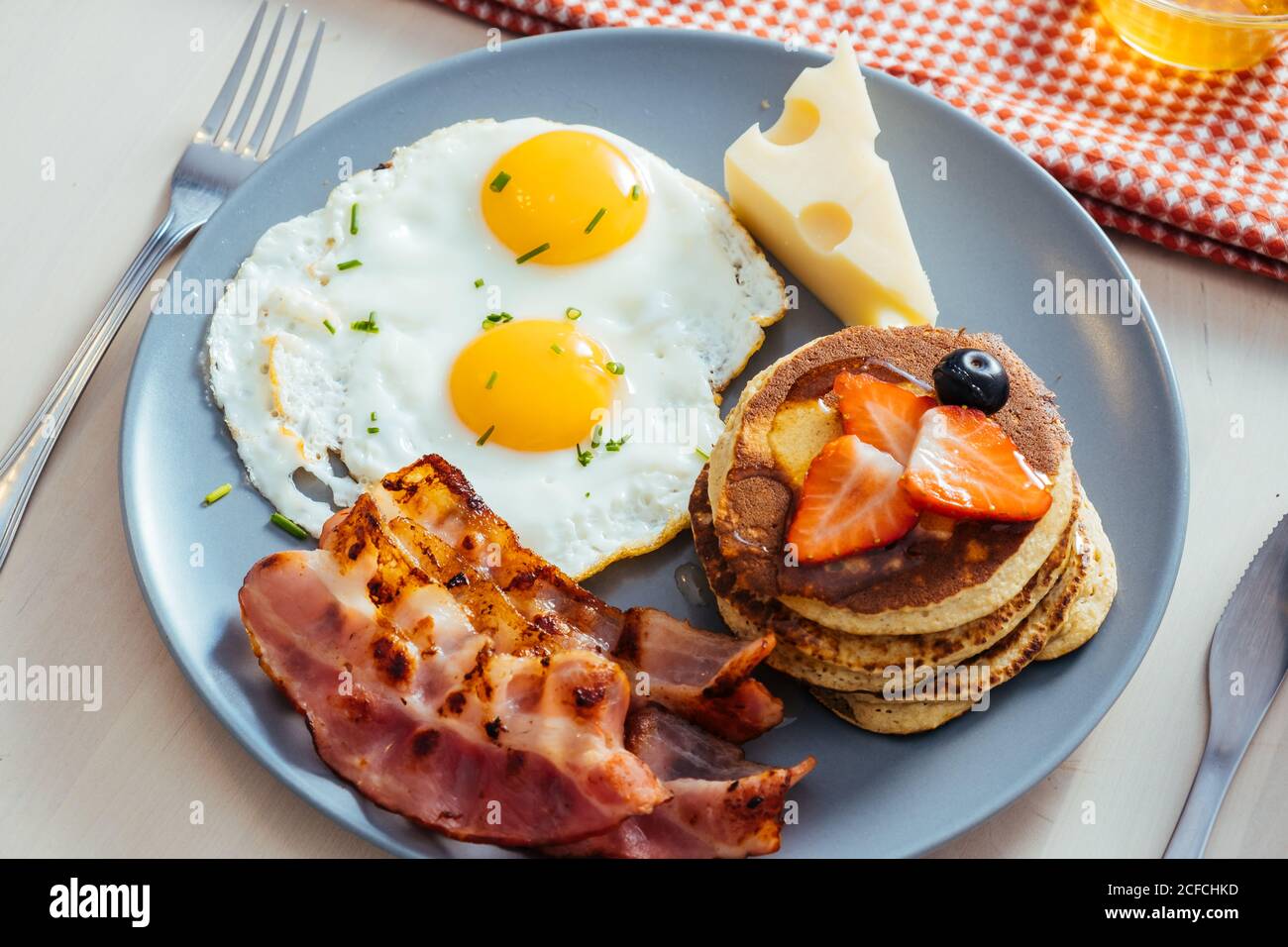 Delicious fried eggs with bacon and cheese for breakfast Stock Photo