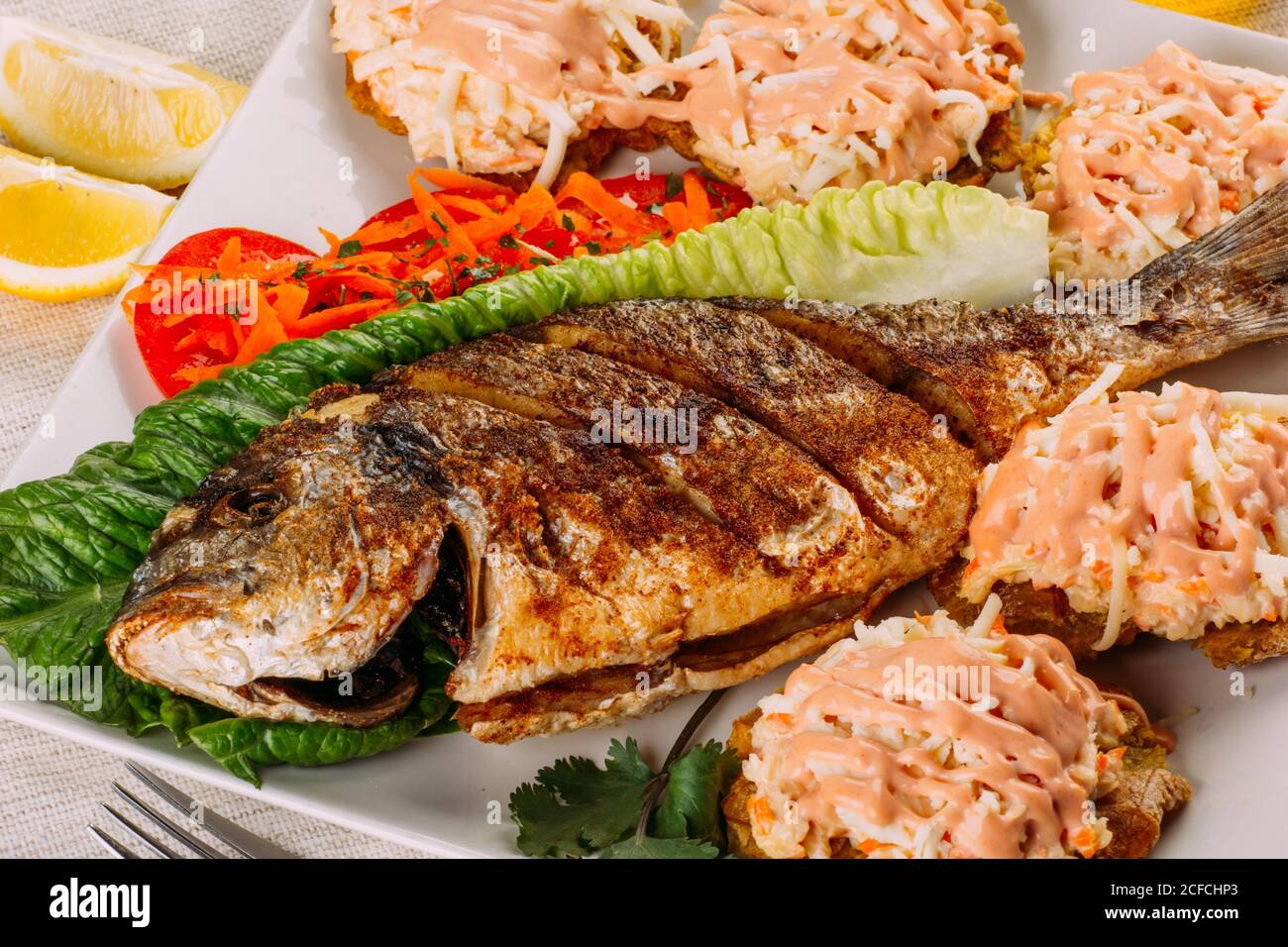 Top view of fried fish, salad and fried plantain Stock Photo