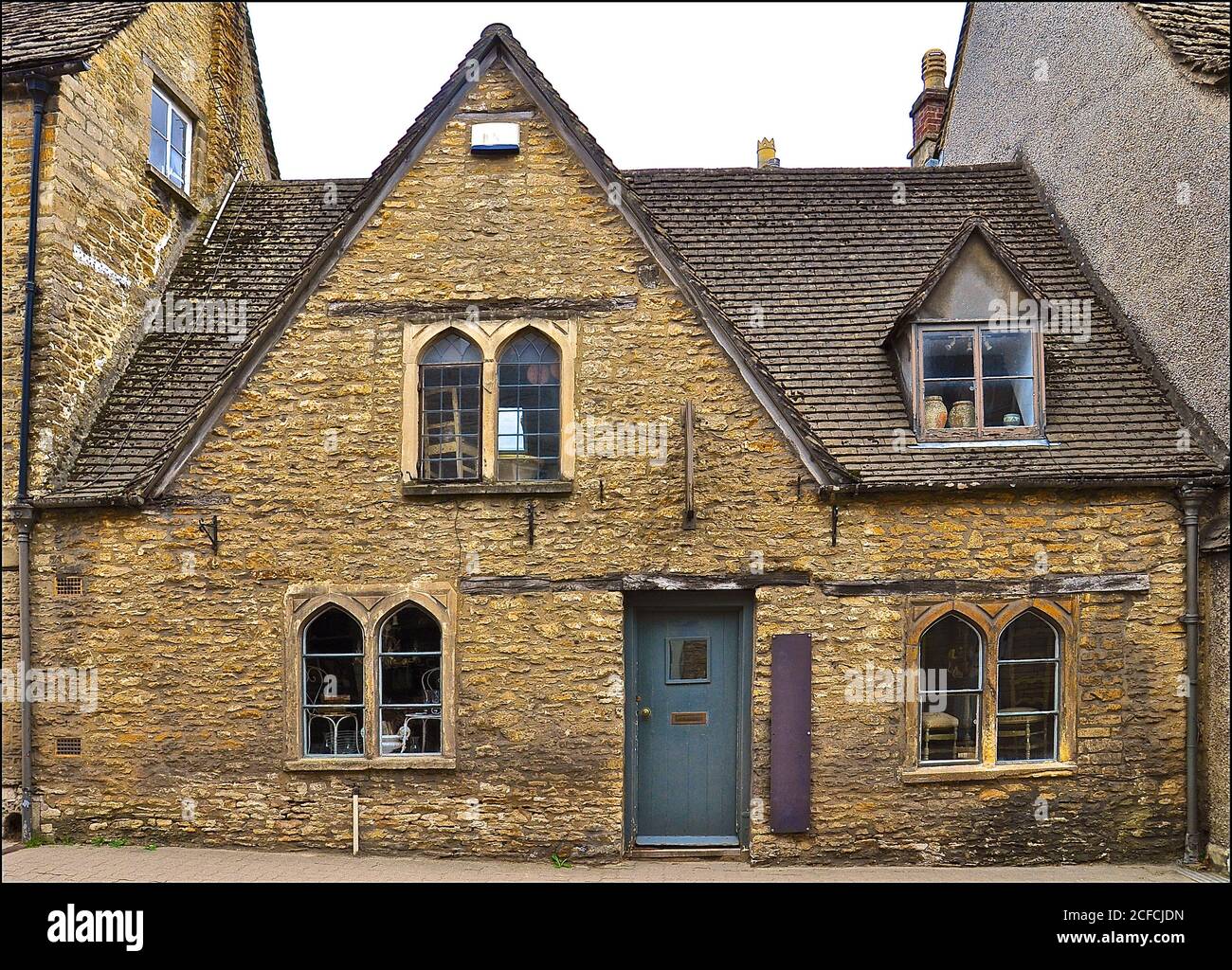 Historic stone house with gothic windows and a gabled stone tiled roof