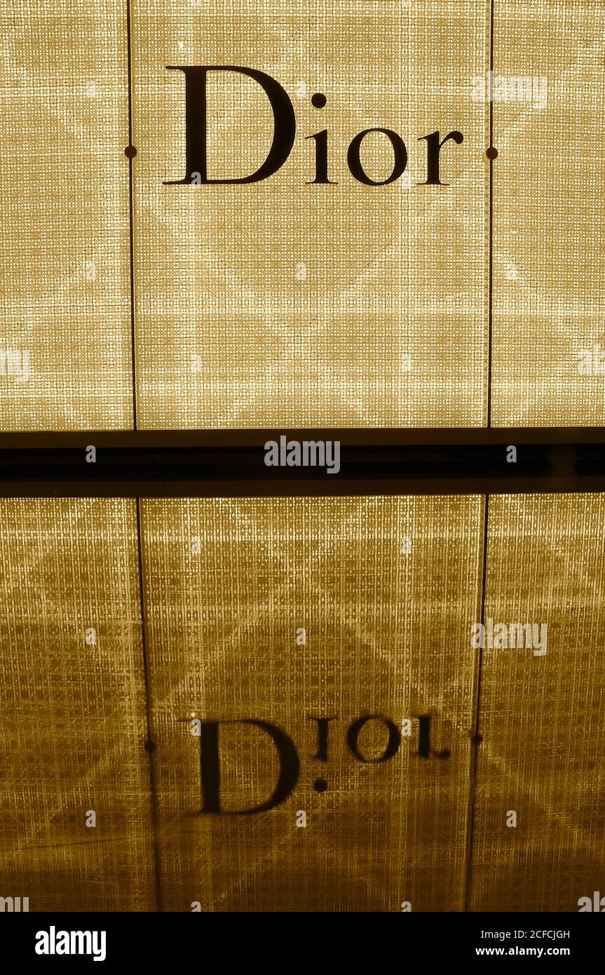 Illuminated Dior shop frontage sign and reflection in the water below. Stock Photo