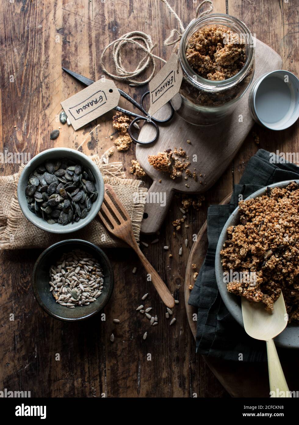 From above yummy millet and quinoa granola and fresh seeds placed on lumber table in kitchen Stock Photo