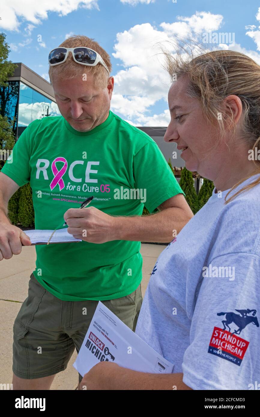 Clinton Township, Michigan, USA. 4th Sep, 2020. People in Michigan's Macomb County sign petitions aiming to repeal the emergency power act that Governor Gretchen Whitmer has used to close businesses and require mask wearing during the coronavirus pandemic. The 'Unlock Michigan' campaign is backed by prominent Republican leaders. Credit: Jim West/Alamy Live News Stock Photo
