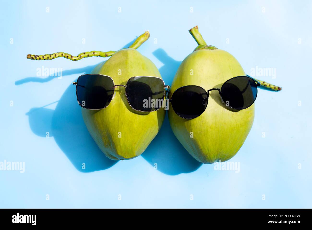 Coconuts with sunglasses on blue background. Stock Photo