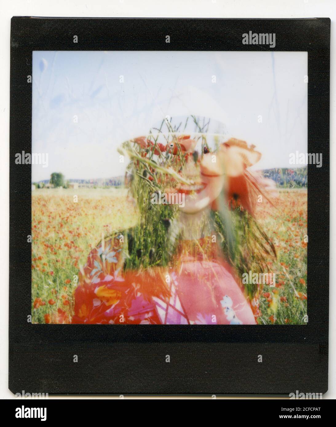 Instant photo of silhouette of cheerful female standing in blooming field on sunny summer day Stock Photo