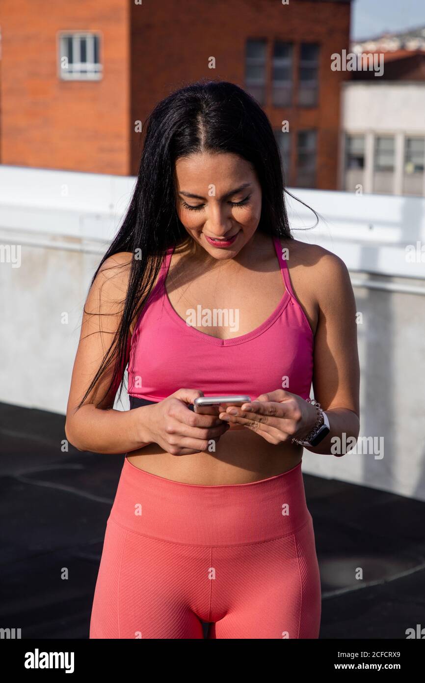 Woman in hoodie with pink sports bra in a gym. very shallow depth of field  for softness. Stock Photo