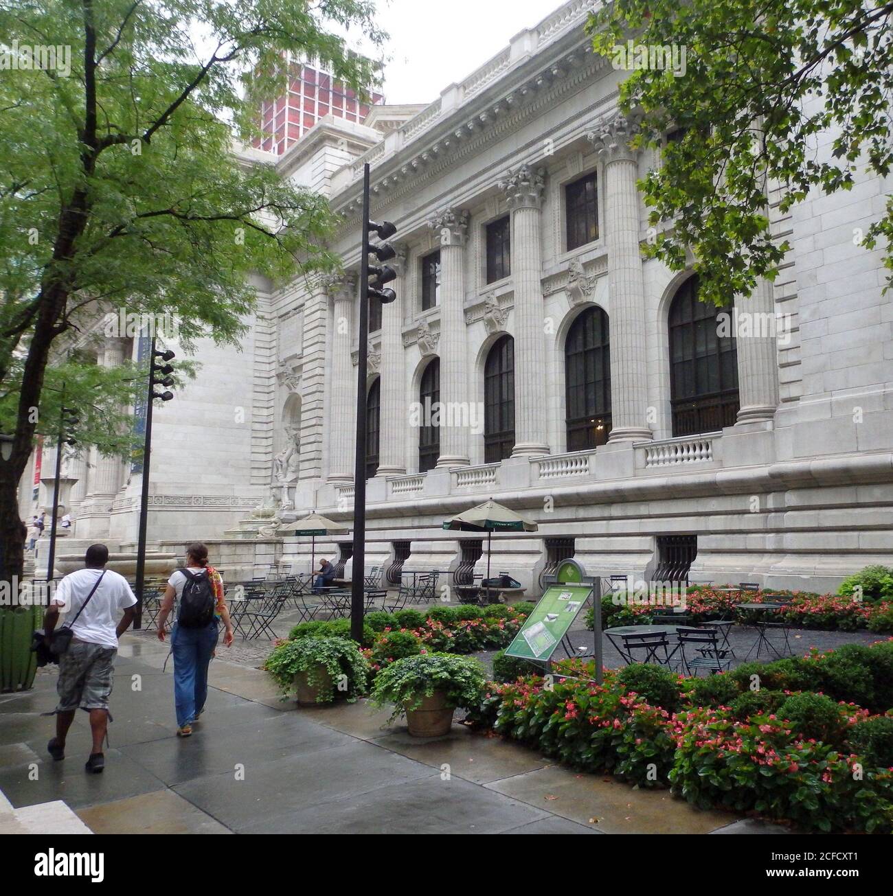 The New York City Public Library building surrounded by green plants and trees, New York City, United States Stock Photo
