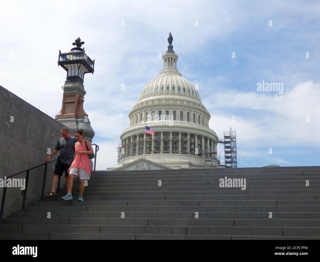 Two tourists walk down the stairs with The United States Capitol Building in the background, Washington DC, United States Stock Photo