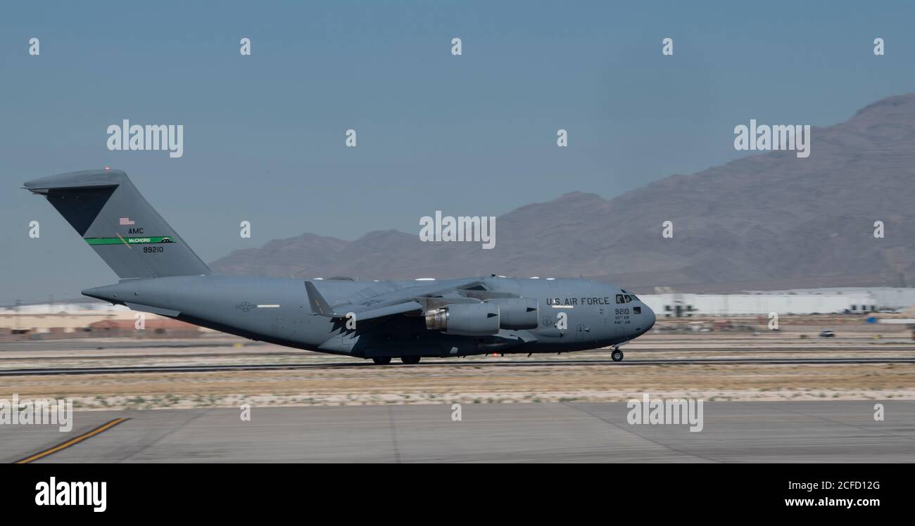 A C-17 Globemaster III from the 62nd Airlift Wing lands at simulated austere base during the Advanced Battle Management System exercise on Nellis Air Force Base, Nev., Sept. 3, 2020. The ABMS is an interconnected battle network - the digital architecture or foundation - which collects, processes and shares data relevant to warfighters in order to make better decisions faster in the kill chain. In order to achieve all-domain superiority, it requires that individual military activities not simply be de-conflicted, but rather integrated – activities in one domain must enhance the effectiveness of Stock Photo