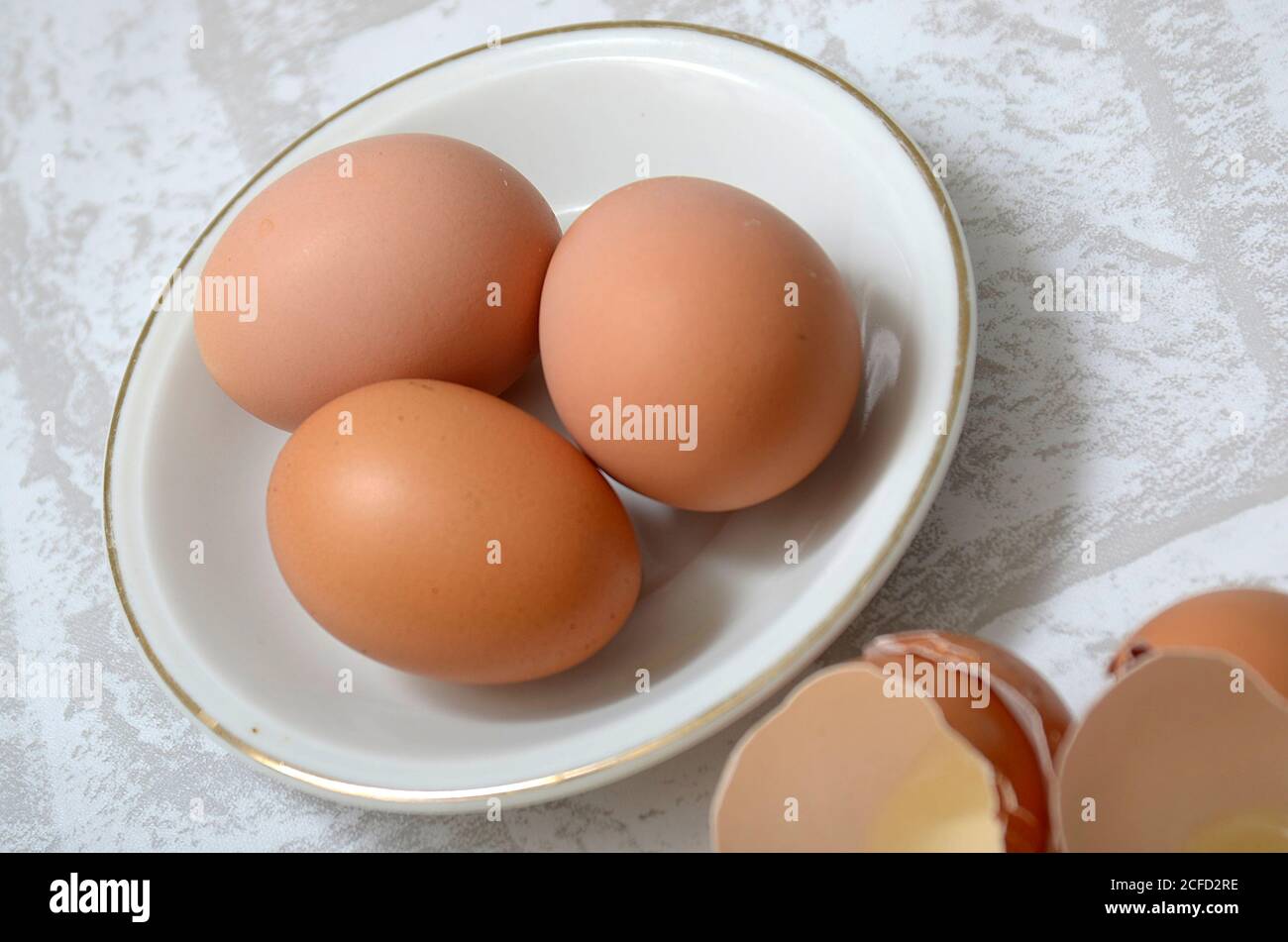 Three eggs in a white bowl Stock Photo