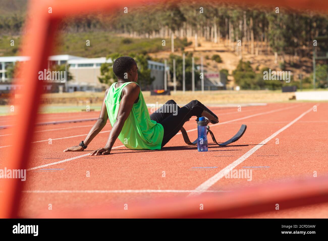 Male athlete with prosthetic legs sitting on race track Stock Photo - Alamy